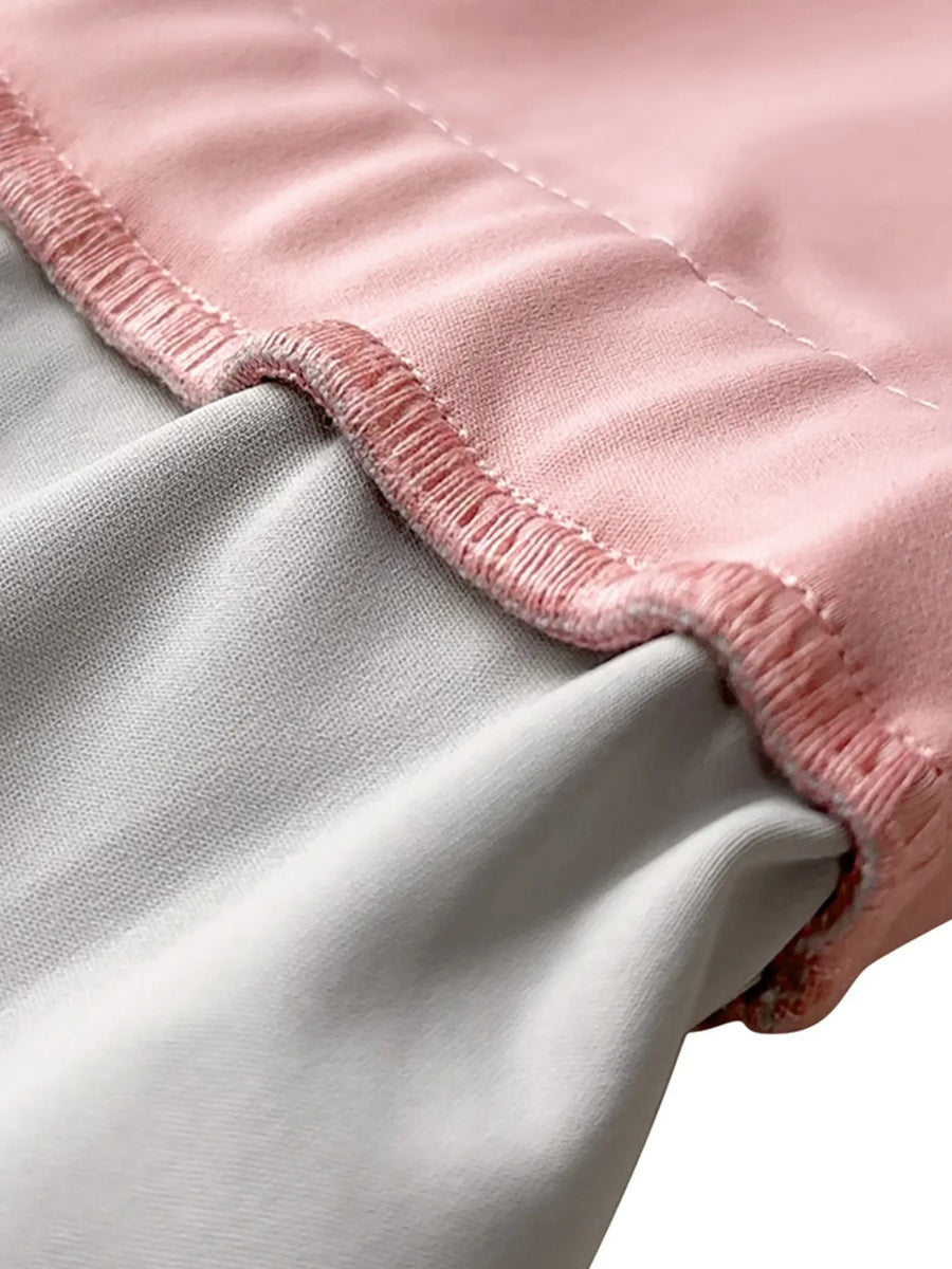Close-up of a pink and gray blanket with frayed edges.