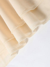Close-up of beige fabric with a textured pattern on a white background