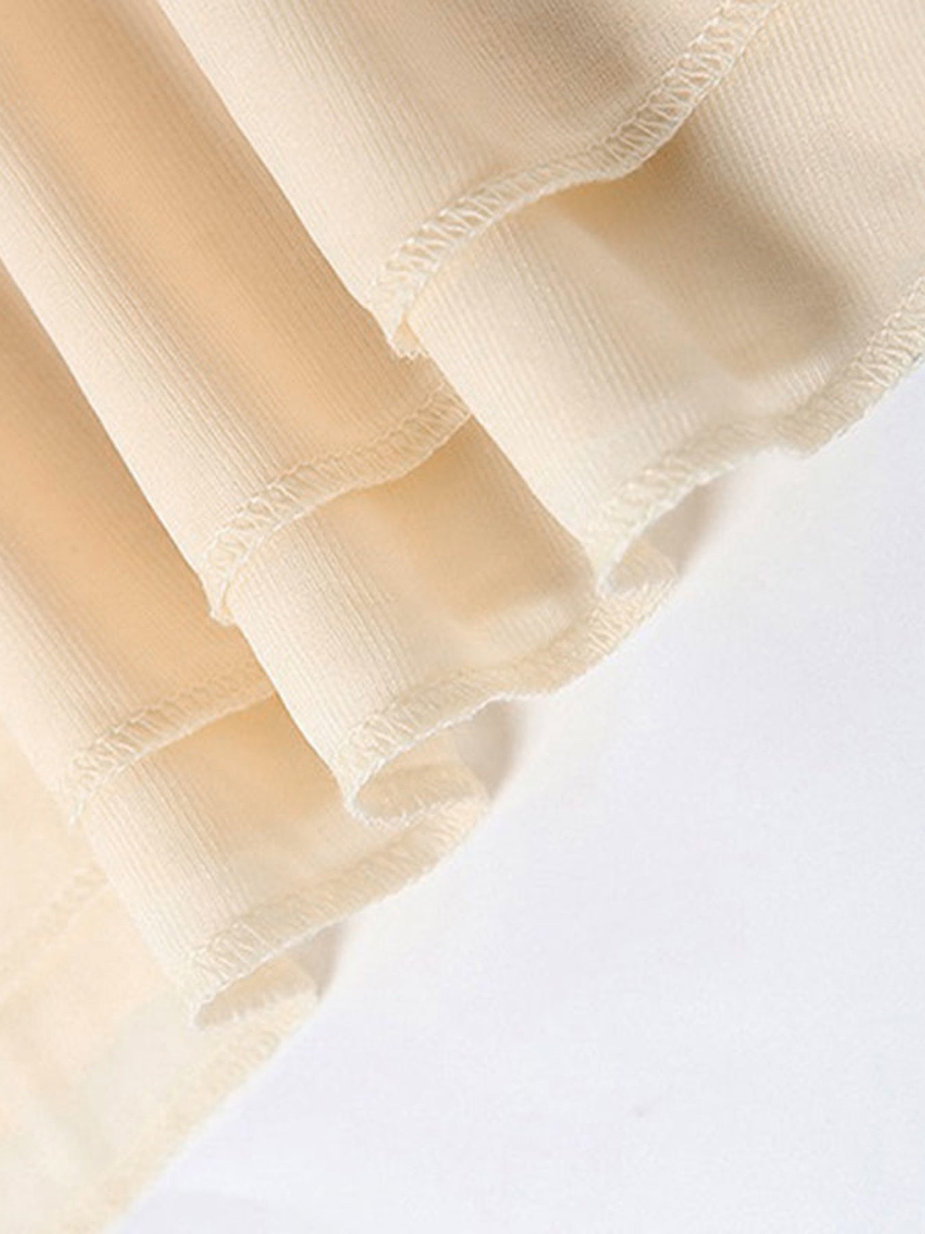 Close-up of beige fabric with a textured pattern on a white background