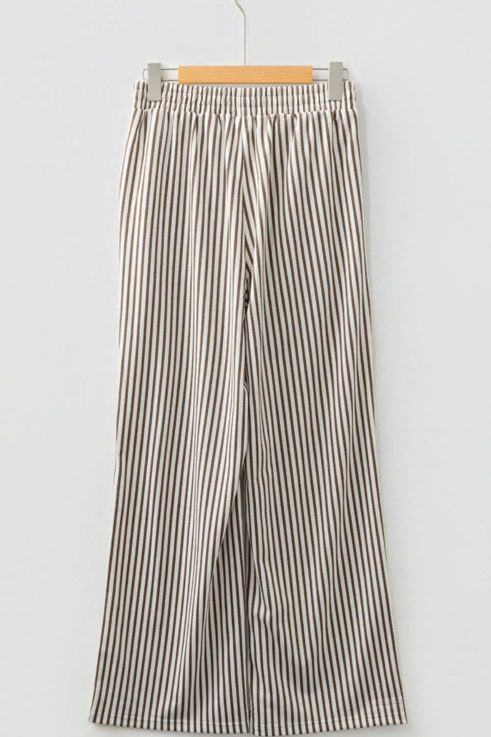 Striped pants on a hanger against a white background