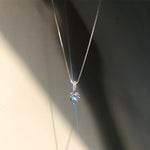 Silver necklace with a diamond pendant on a dark background