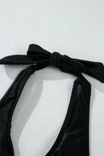 Black bikini top with a bow on a white background