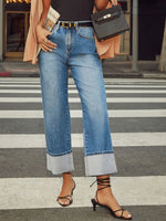 Person wearing blue jeans and black sandals on a crosswalk