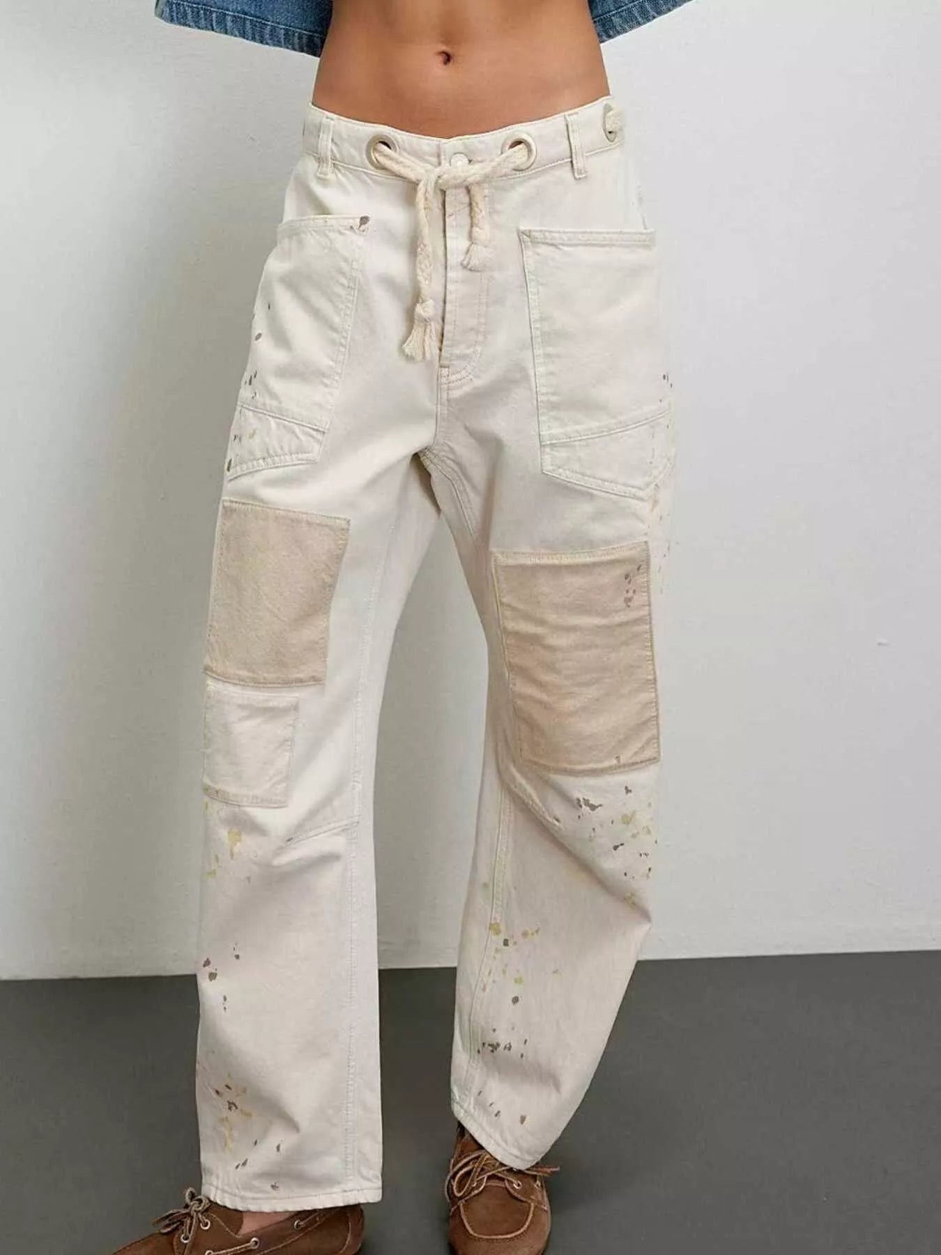 Front view of woman wearing white patched jeans