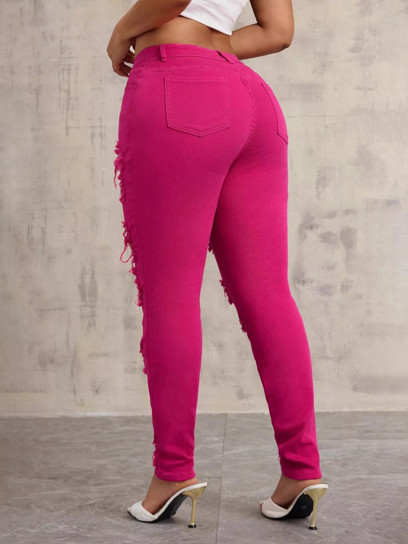 Person wearing bright pink jeans with a neutral background