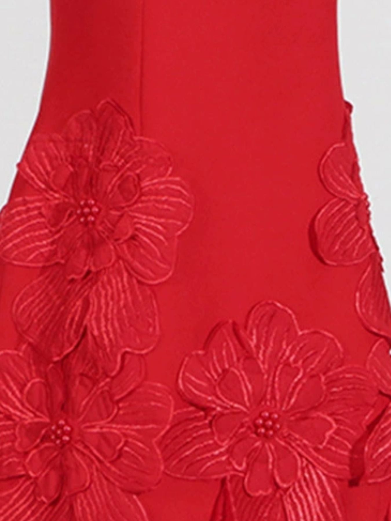 Red fabric with floral embroidery on a white background