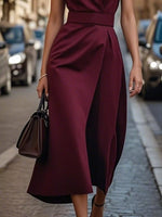 Woman wearing a burgundy dress on a city street.
