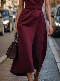 Woman wearing a burgundy dress on a city street.