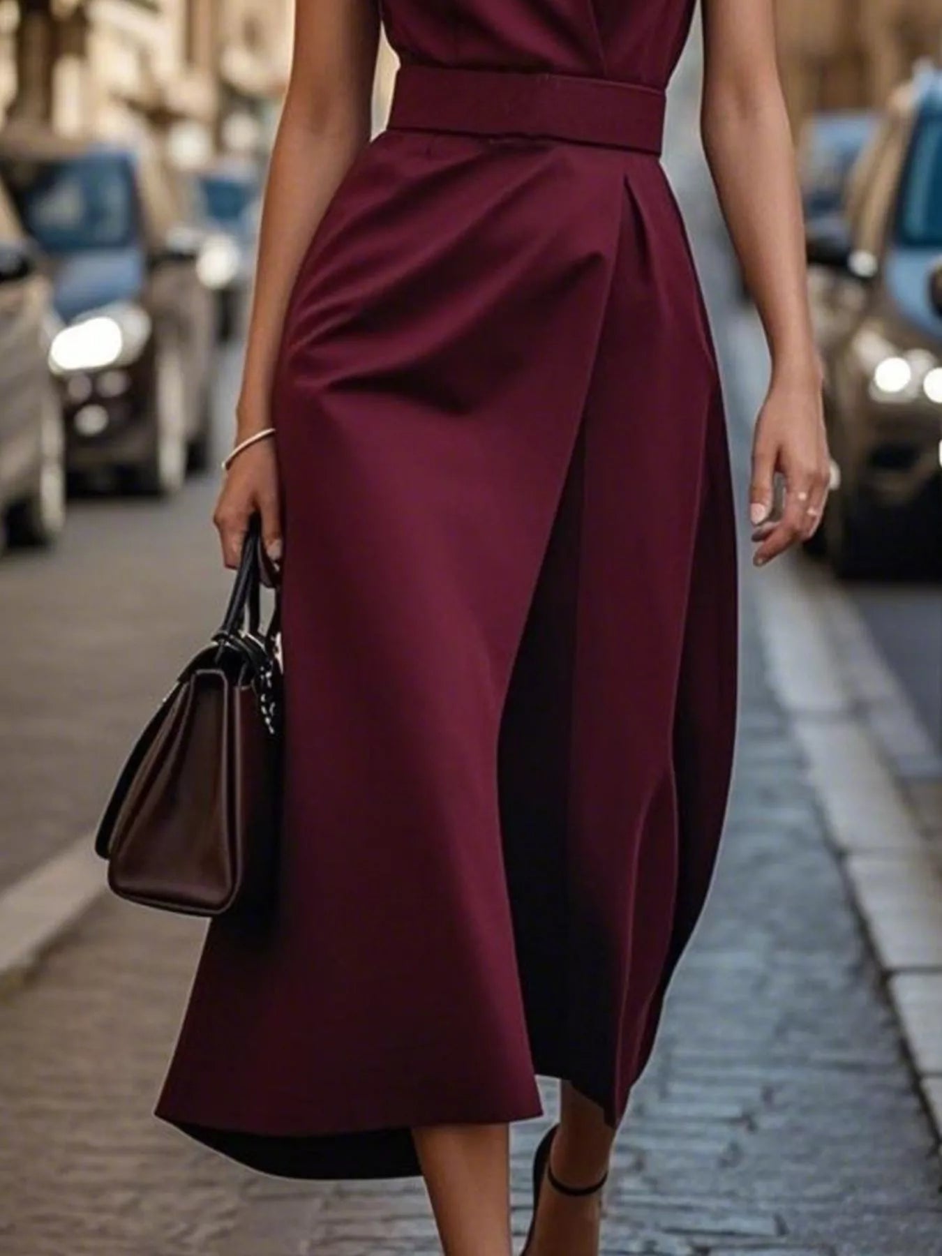 Woman wearing a burgundy dress on a city street.