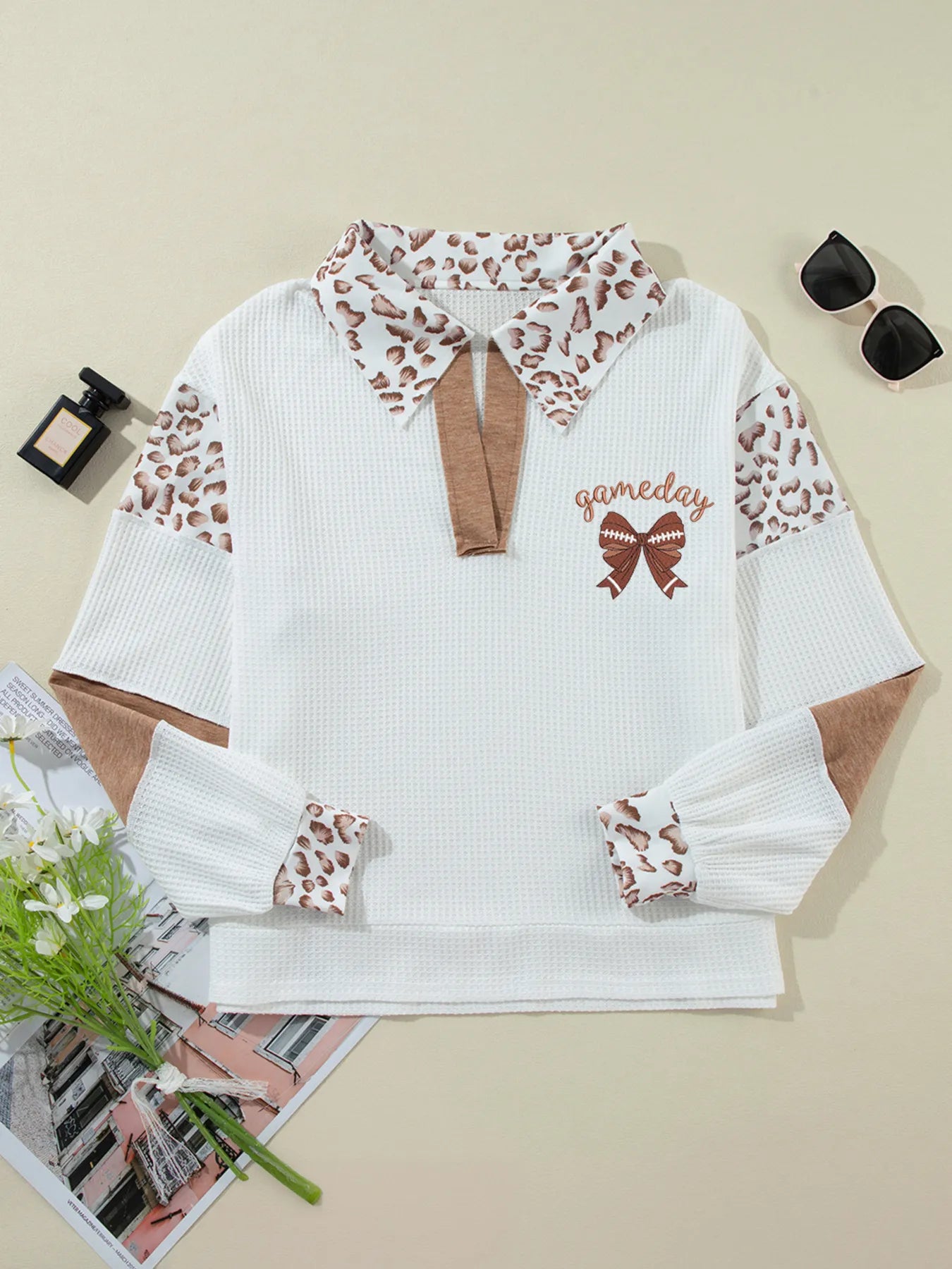 White sweater with leopard print accents on a beige background
