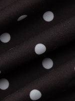 Close-up of black fabric with white polka dots