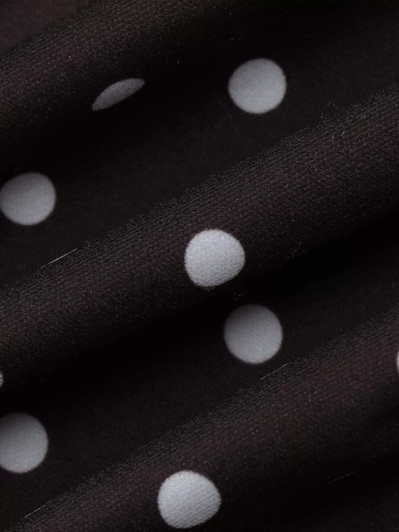 Close-up of black fabric with white polka dots
