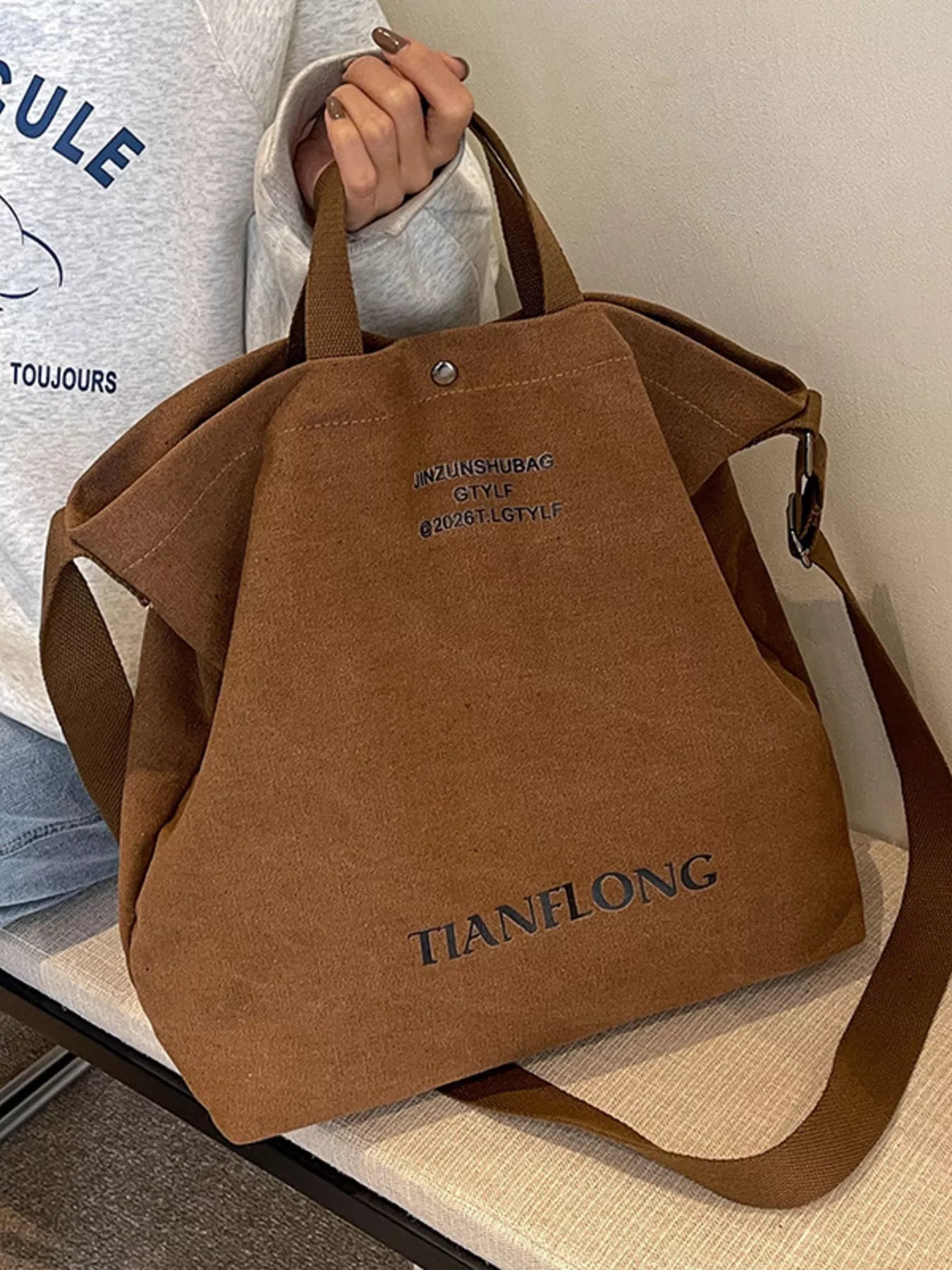 Brown bag with 'TIANELONG' branding held by a person wearing a white shirt.
