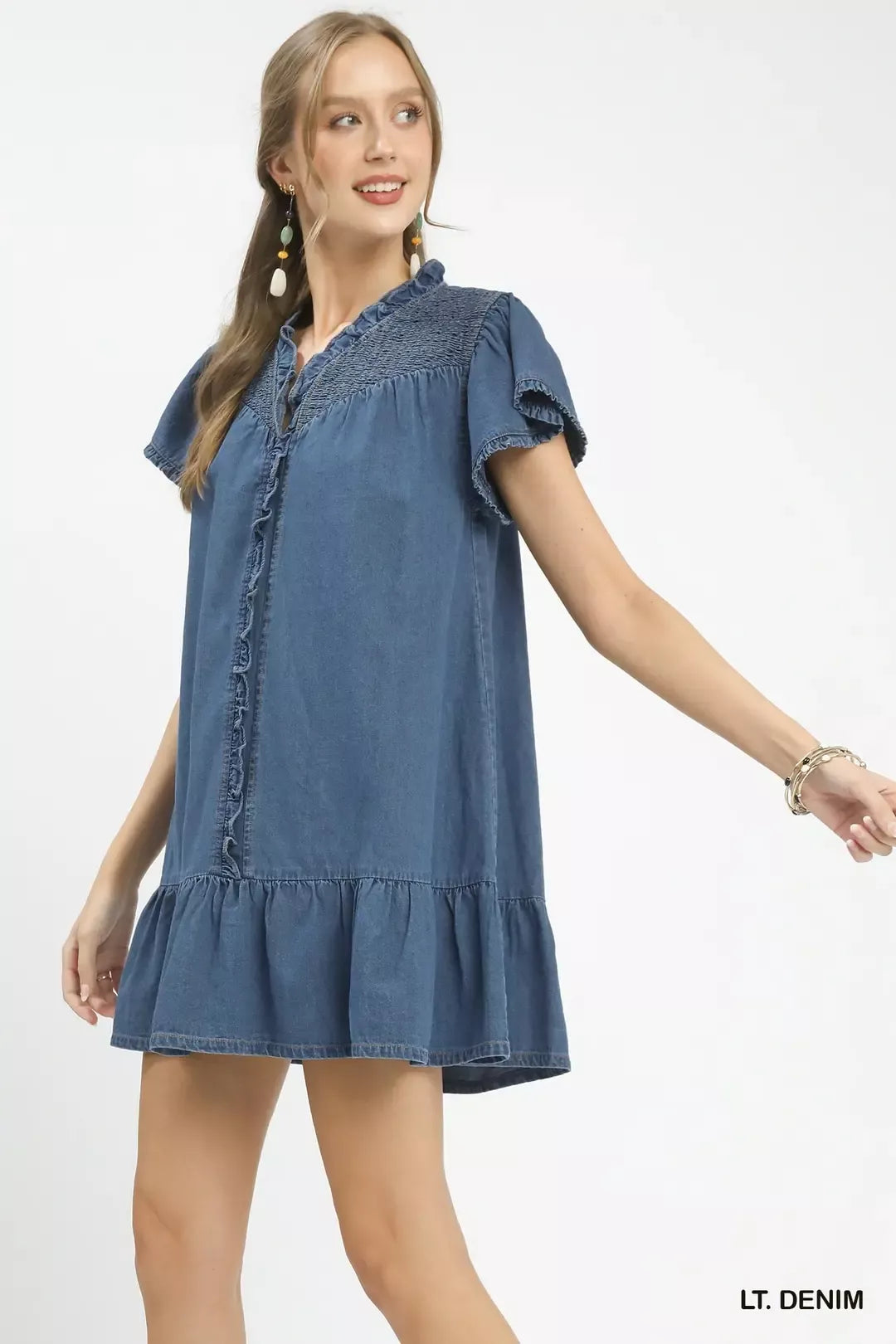 Woman wearing a light denim dress on a white background