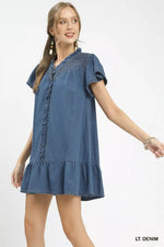 Woman wearing a light denim dress on a white background