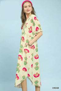 Woman wearing a cream floral dress against a light blue background