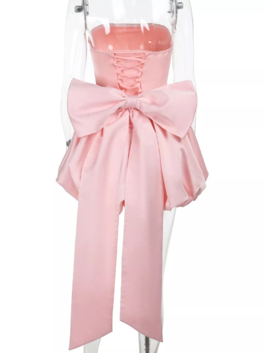 Pink dress with a large bow on a mannequin against a white background