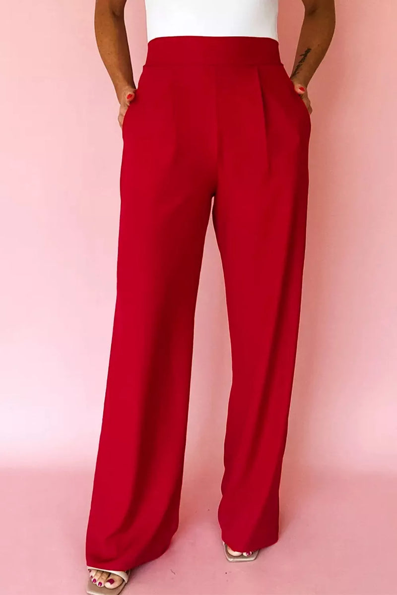 Red wide-leg pants worn by a person on a pink background