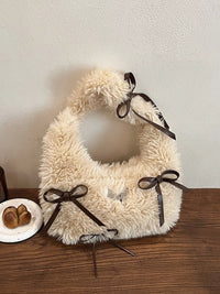 White fluffy bag with brown ribbons on a wooden surface