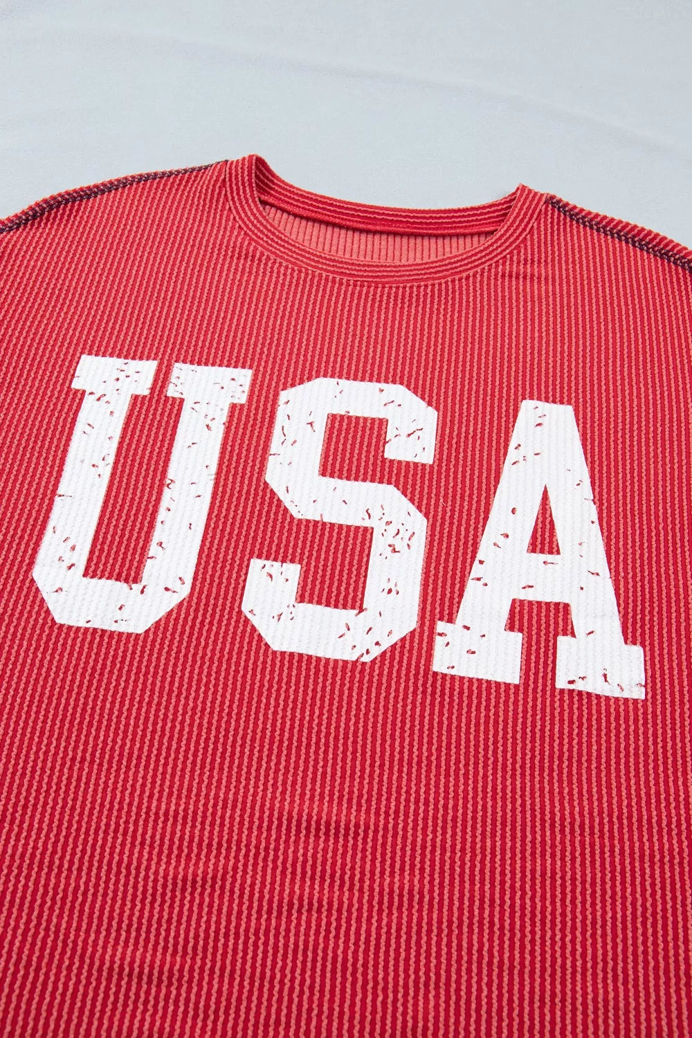 Red shirt with 'USA' printed in white on a light gray background
