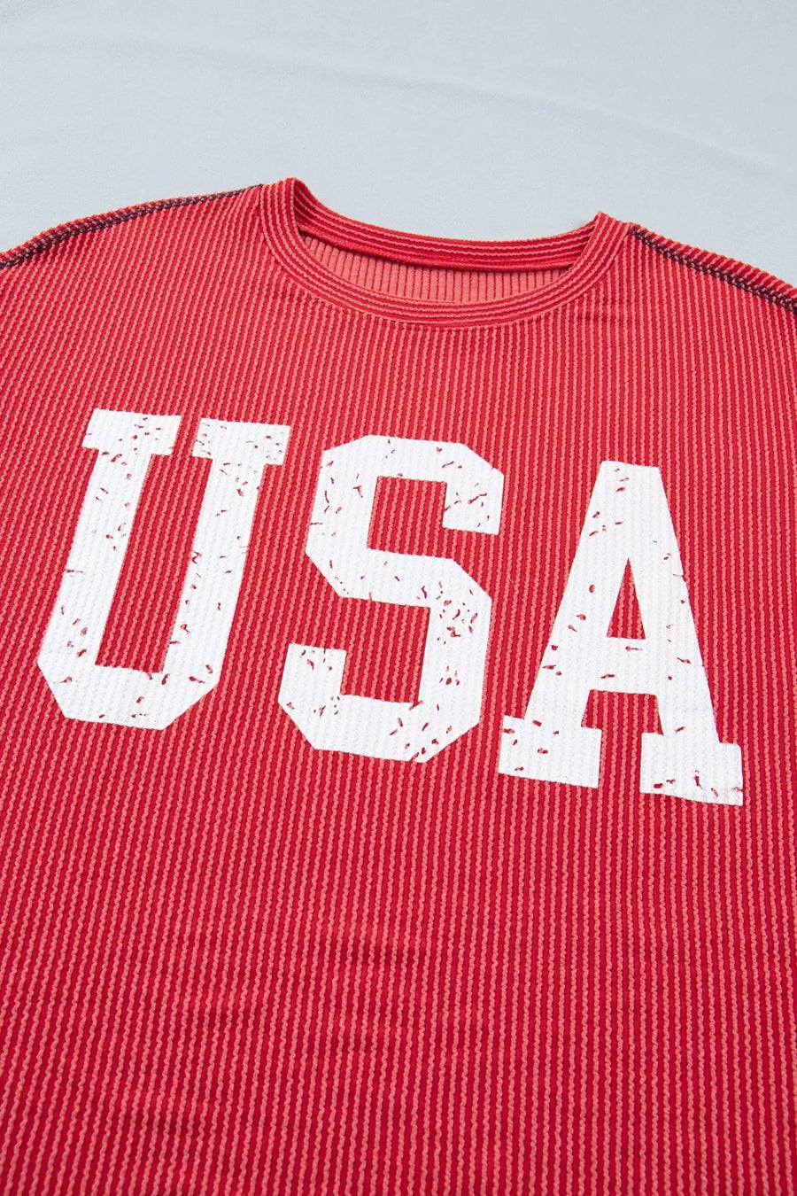 Red shirt with 'USA' printed in white on a light gray background