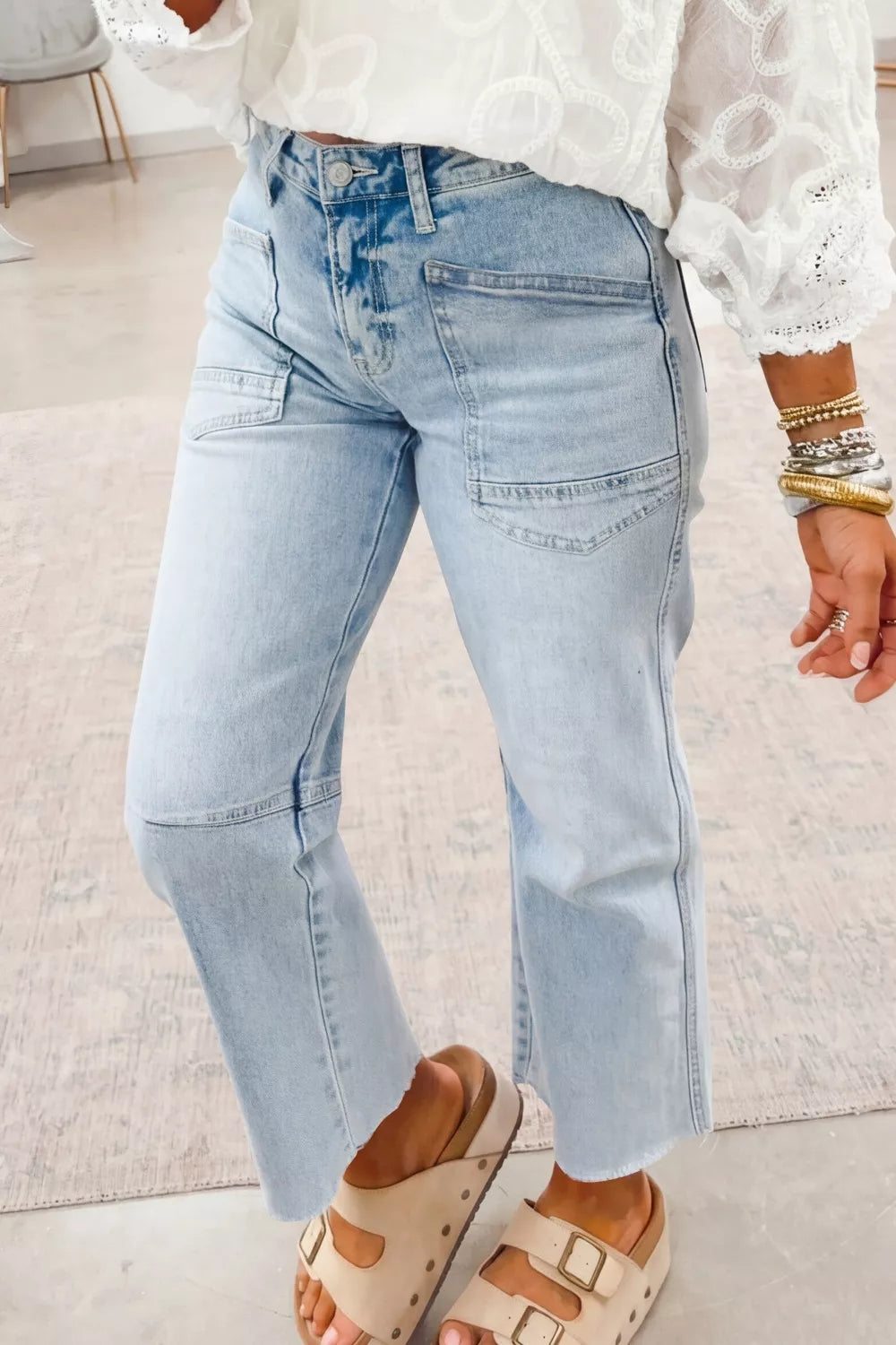 Light blue jeans worn by a person on a light-colored floor.