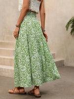 Person wearing a green and white patterned skirt standing on a staircase.