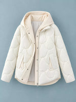 A cream-colored quilted puffer jacket with a hood, shown flat against a solid blue-gray background.