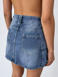 Blue denim skirt worn by a person on a white background