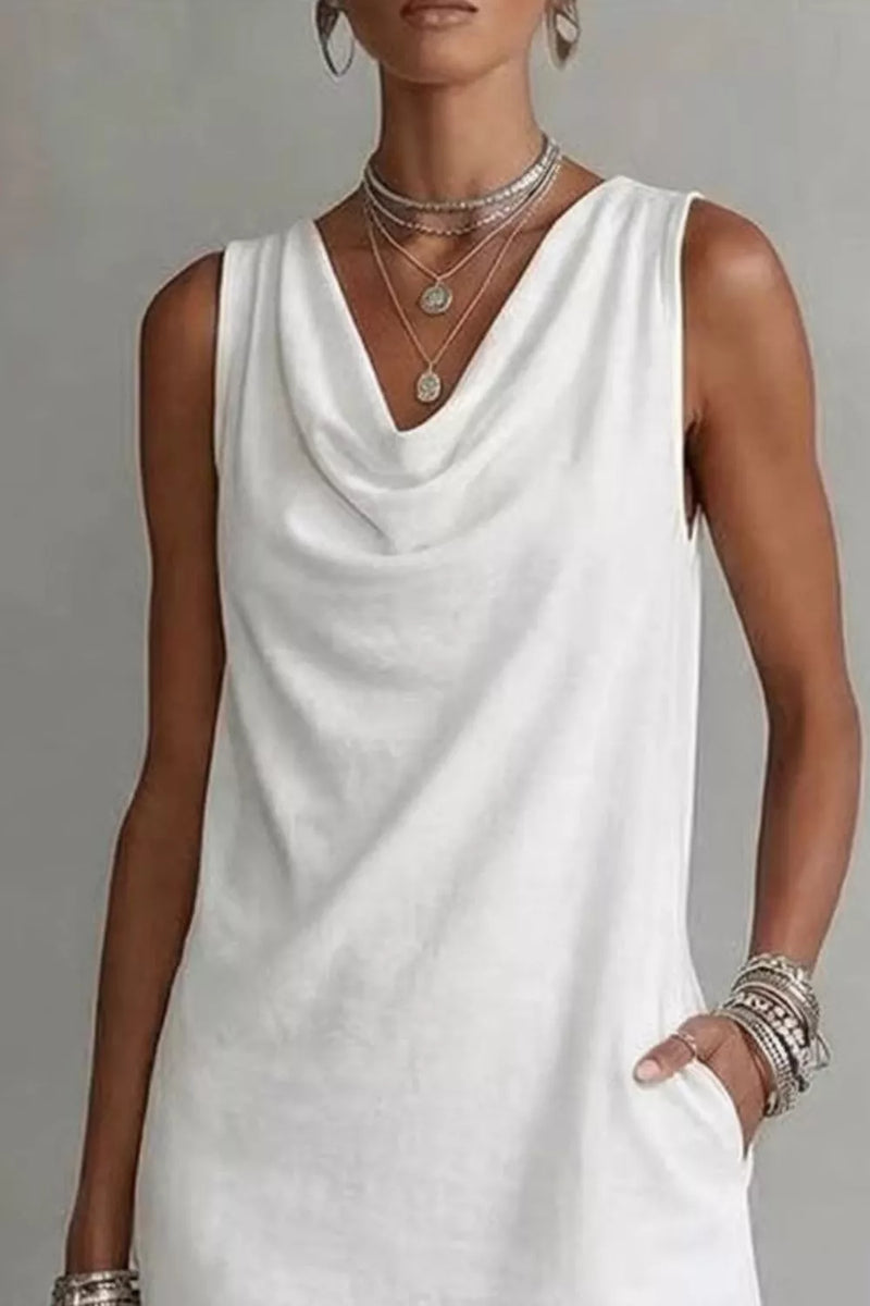 Woman wearing a white sleeveless dress with layered necklaces and bracelets on a gray background