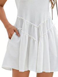 White dress with ruffled hem on a plain background