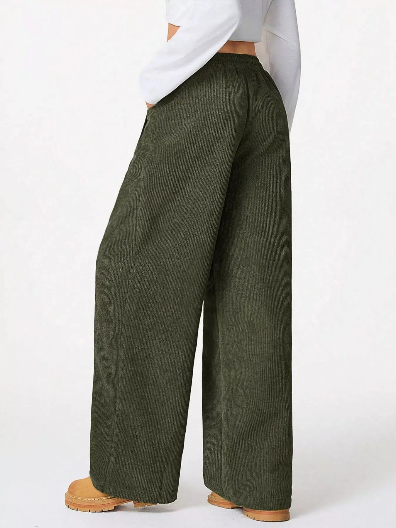 Green wide-leg pants worn by a person on a white background