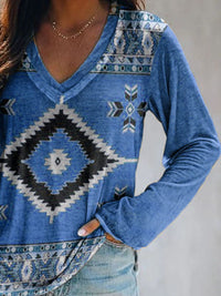 Blue patterned long-sleeve top worn by a person against a neutral background