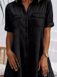Black denim dress worn by a person with a neutral background