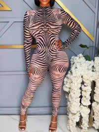 Person wearing a zebra print outfit standing in front of a decorative wall with flowers.