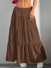 Brown tiered skirt worn by a person on a plain background