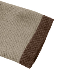 Close-up of a textured fabric with a gradient from beige to brown on a white background