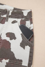 Cow print jeans with a smartphone in the pocket on a beige background