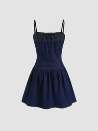 Navy blue dress with thin straps on a light gray background