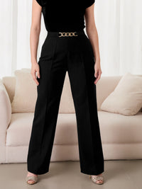 Person wearing black pants with a gold belt in a living room setting