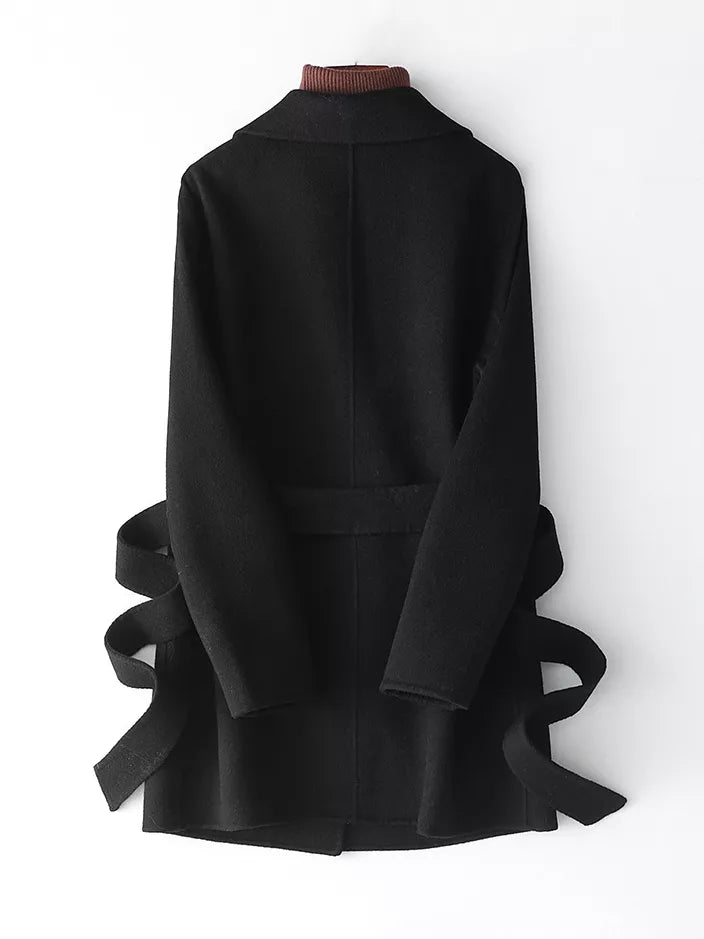 A black long coat with a wide collar and a matching waist belt, shown from the back on a white background.
