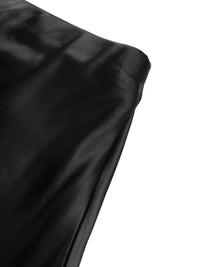 Close-up of black satin fabric on a white background