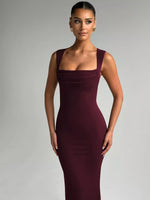 Woman wearing a burgundy evening gown against a gray background
