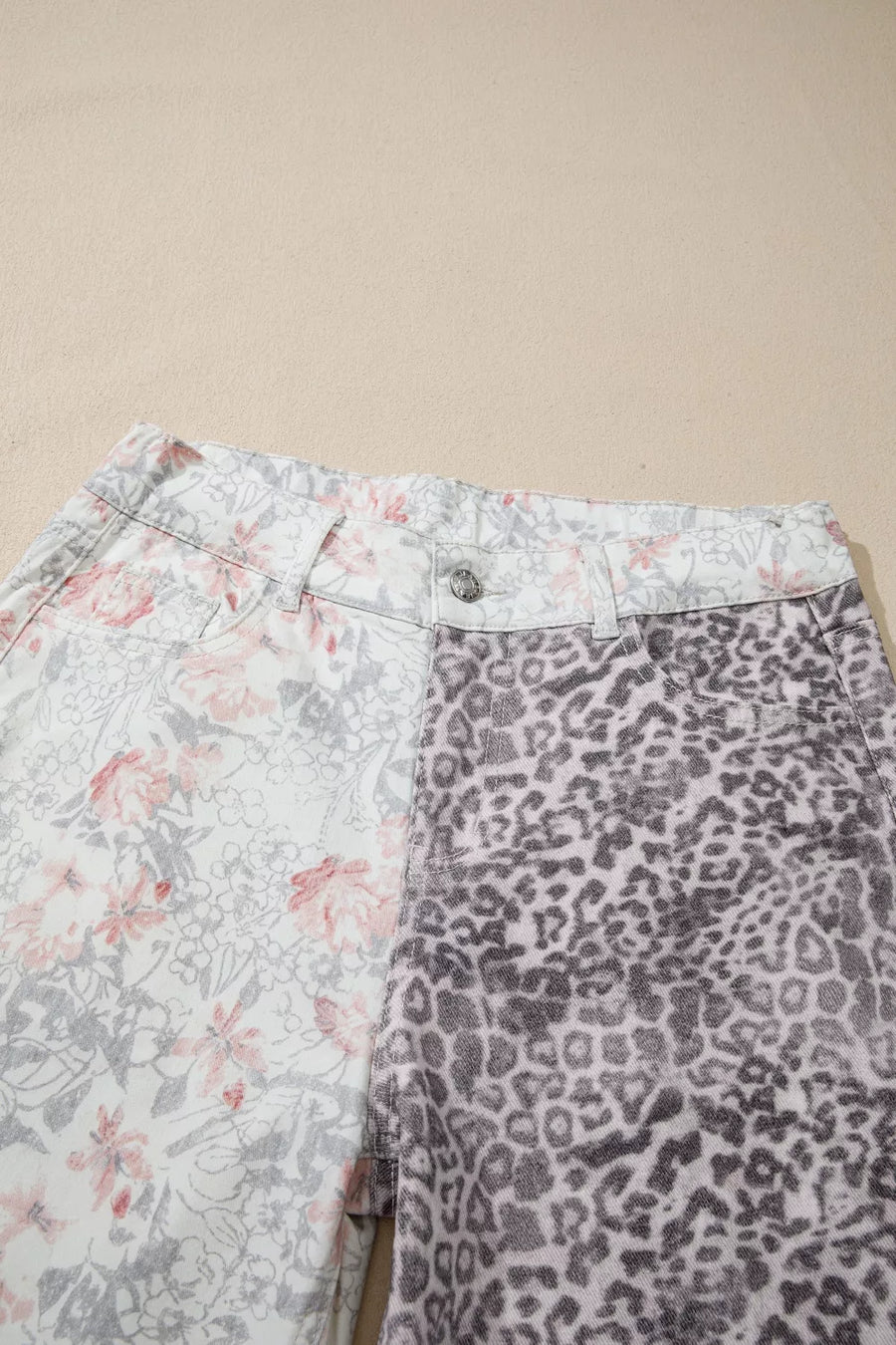 Two pairs of pants with floral and leopard print on a beige background
