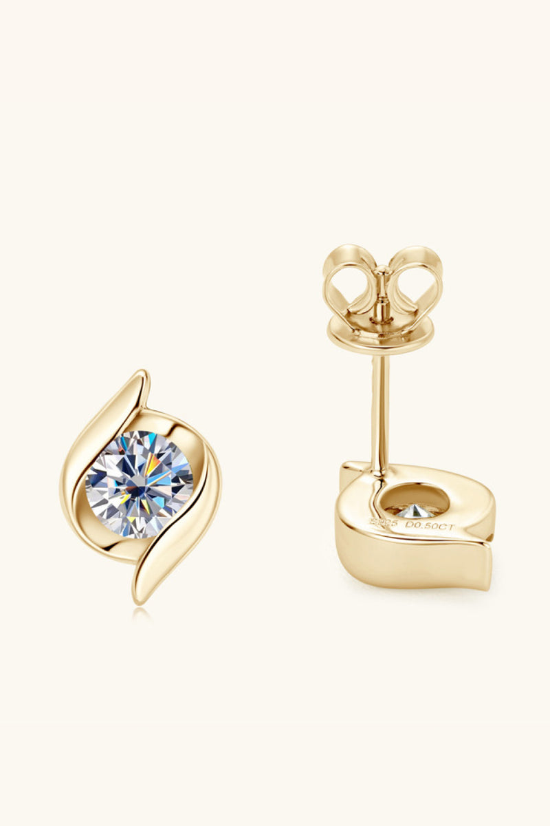 Gold earrings with a central gemstone on a white background