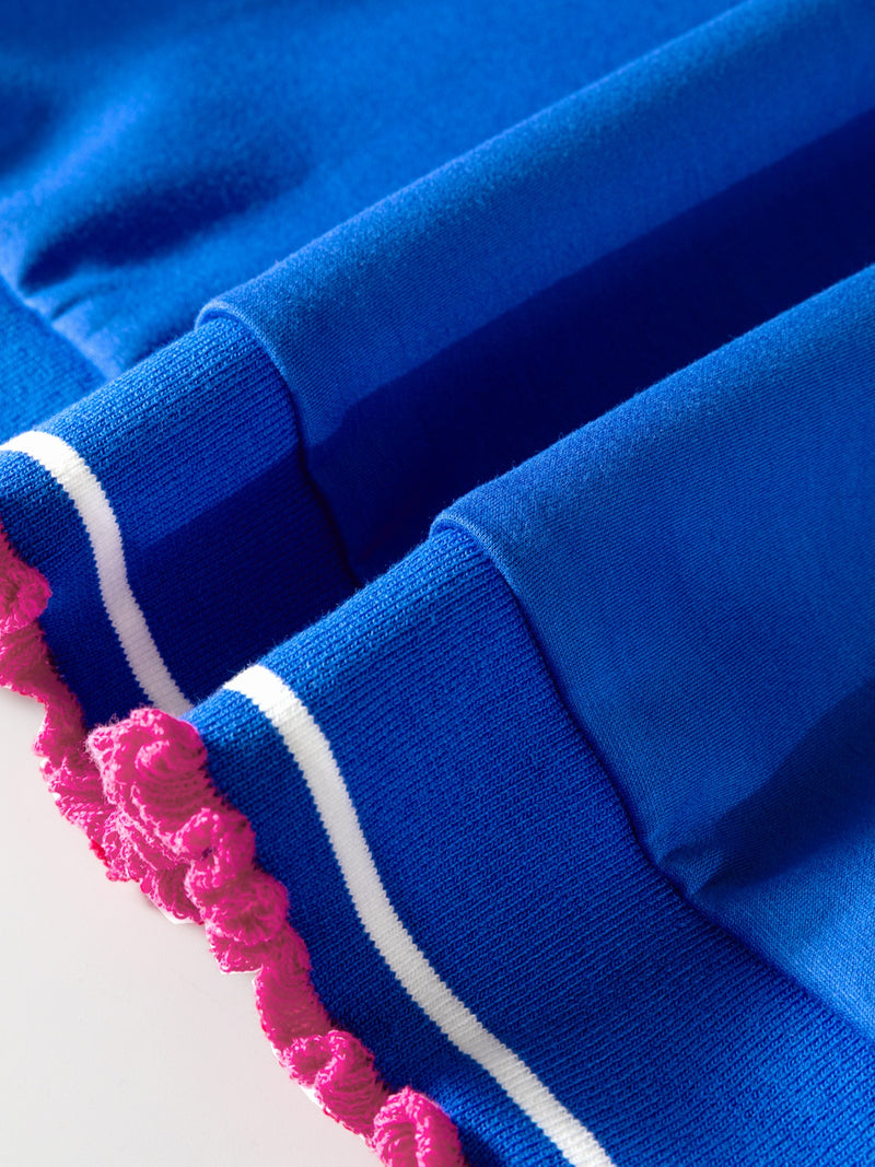 Close-up of blue fabric with pink and white trim