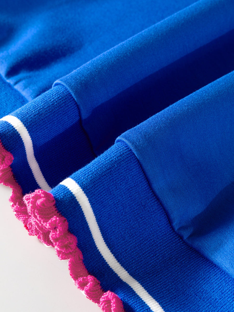 Close-up of blue fabric with pink and white trim