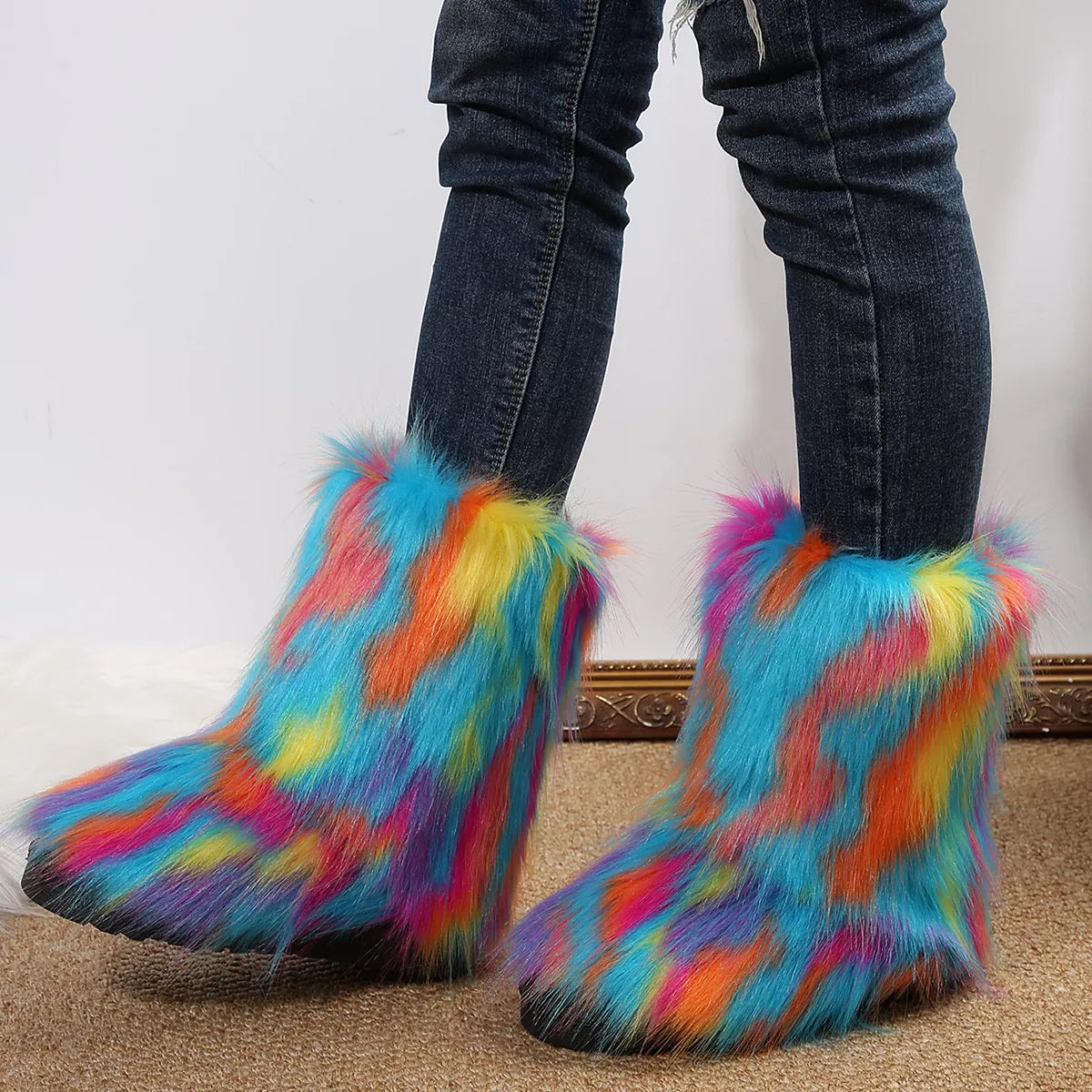Colorful fuzzy boots worn with jeans on a neutral background