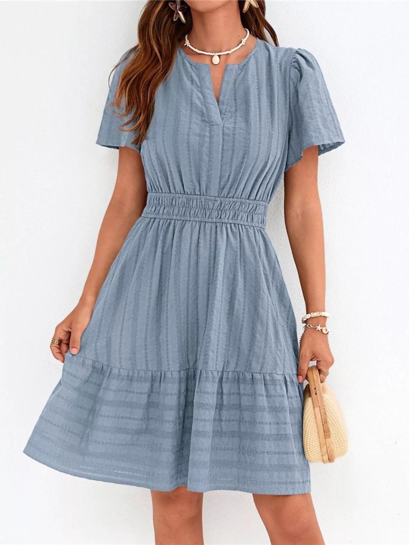 Woman wearing a blue dress with a white background