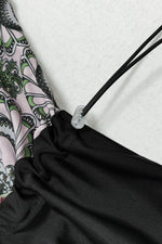 Close-up of a drawstring on a black bag with a patterned fabric background